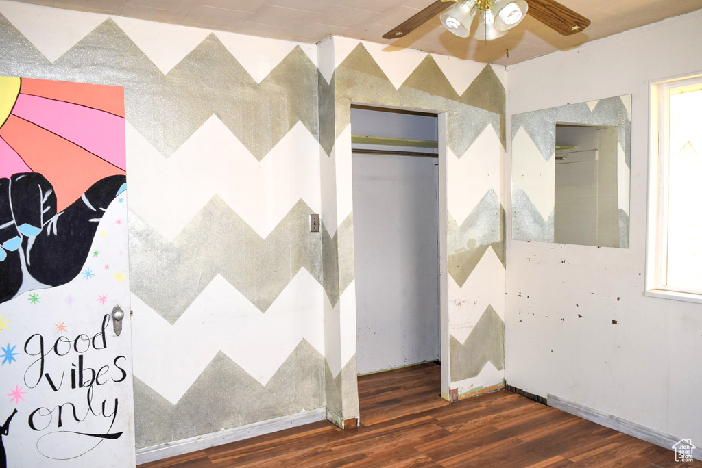 Unfurnished bedroom with wood finished floors and multiple windows