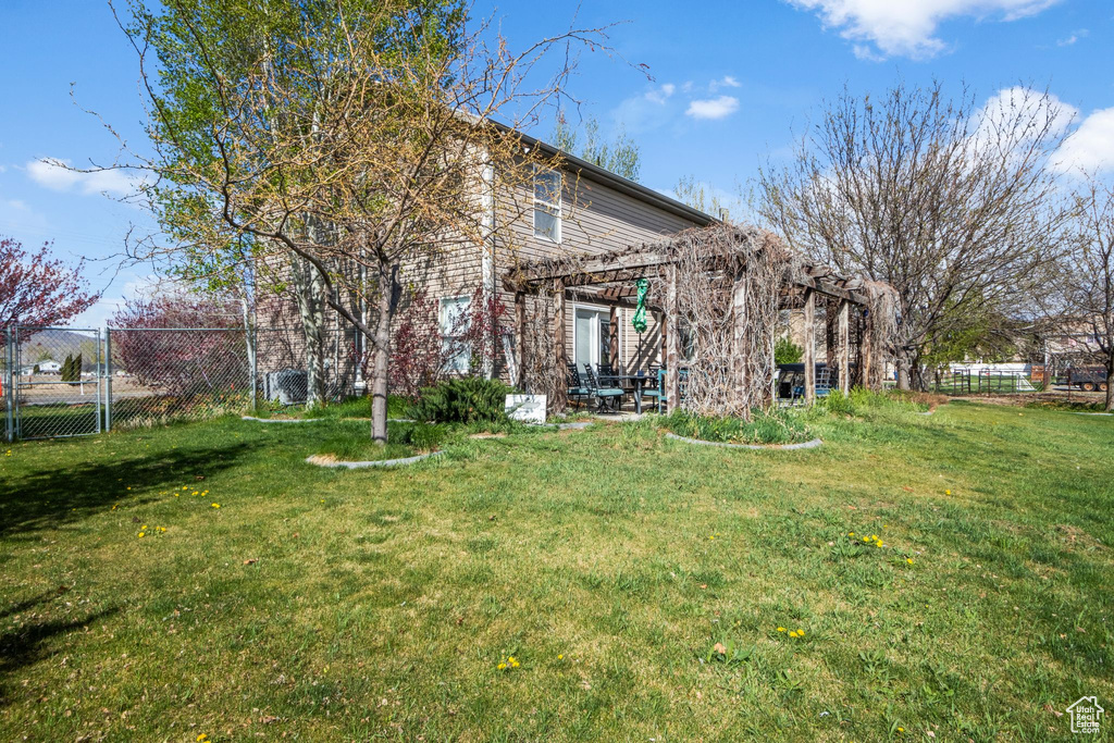 View of yard with fence and a pergola