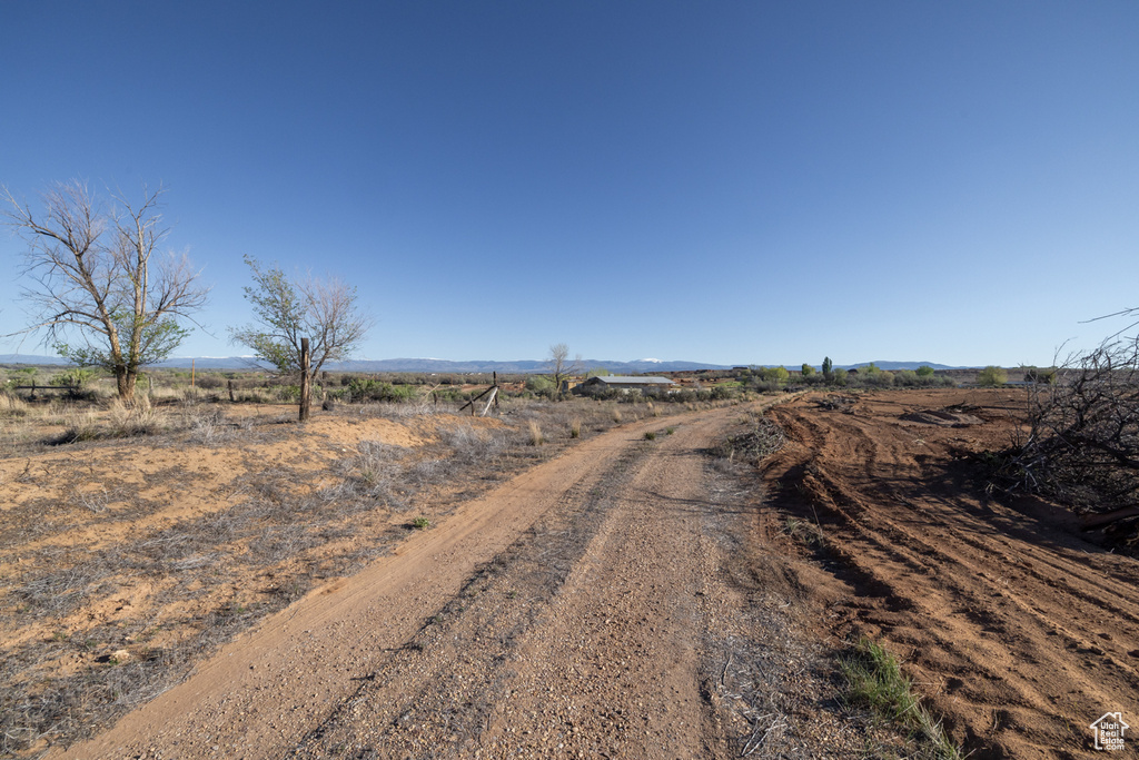 View of dirt / gravel road featuring a view of rural / pastoral area