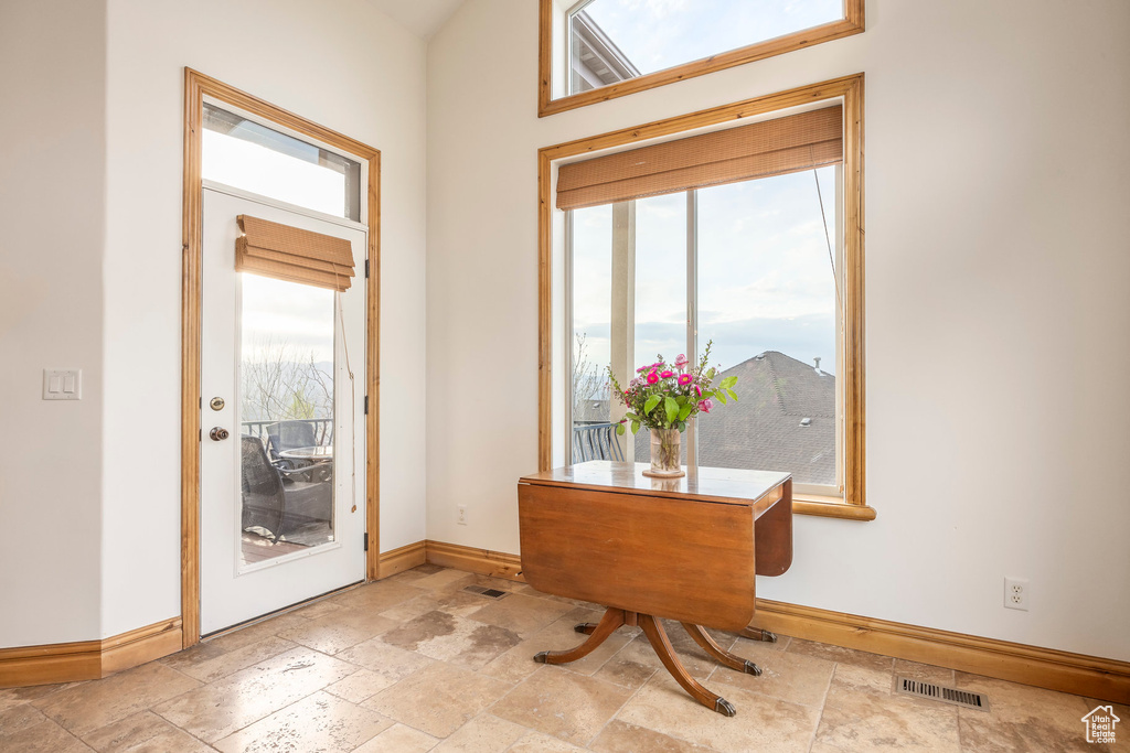 Doorway with stone tile floors, baseboards, and visible vents
