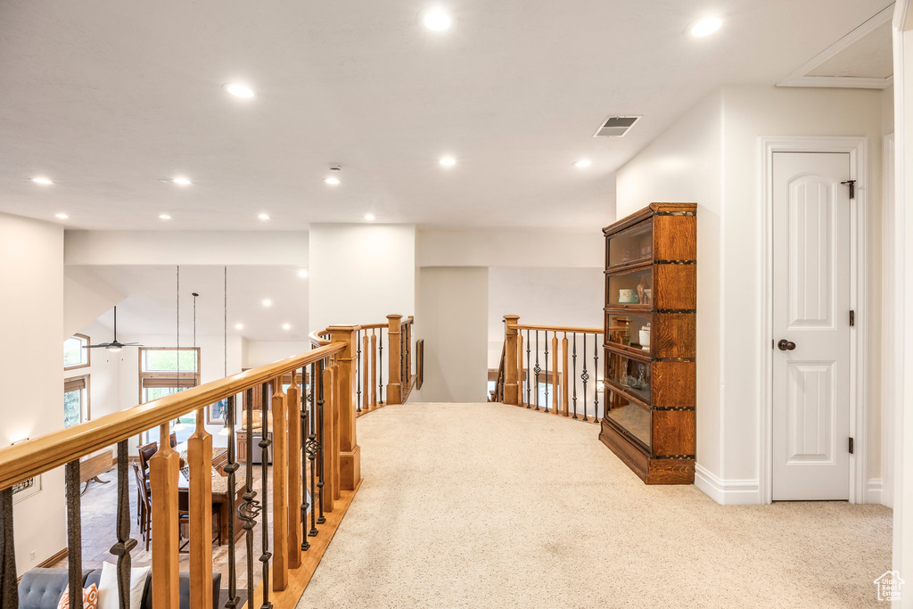Hall with light carpet, an upstairs landing, recessed lighting, and visible vents