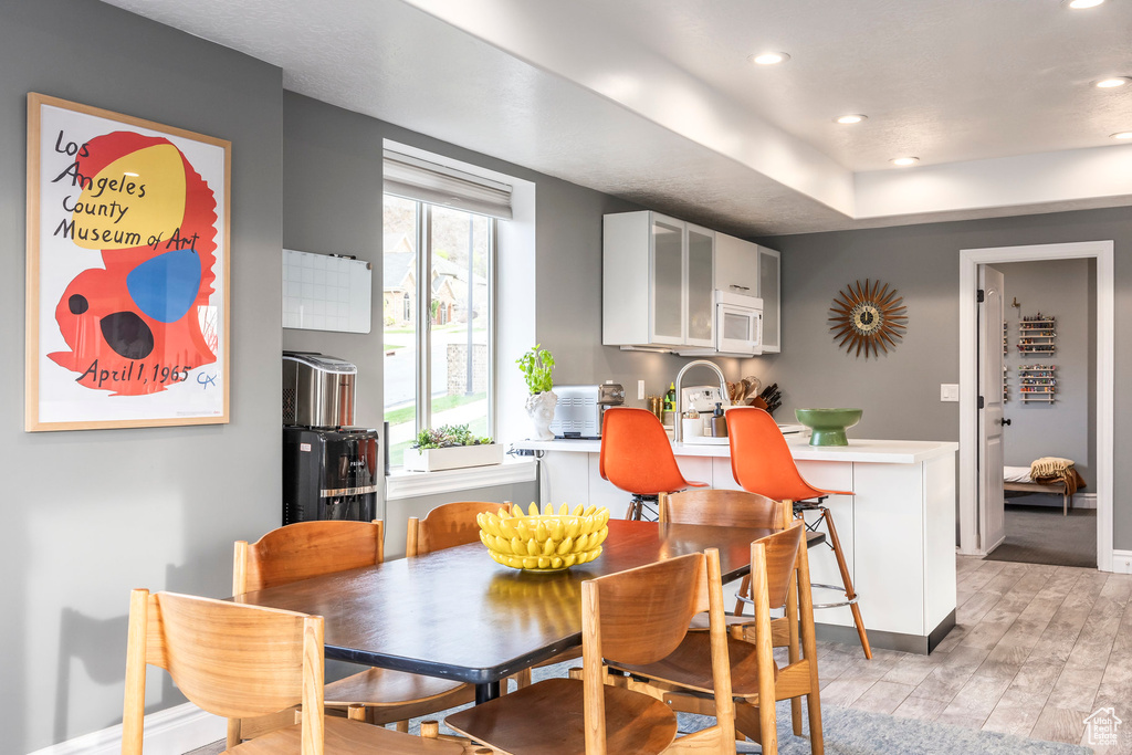 Dining room with recessed lighting, baseboards, and light wood finished floors