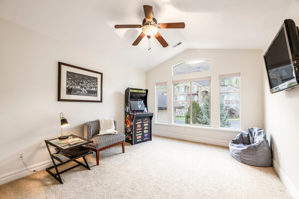 Sitting room with visible vents, carpet floors, baseboards, ceiling fan, and vaulted ceiling