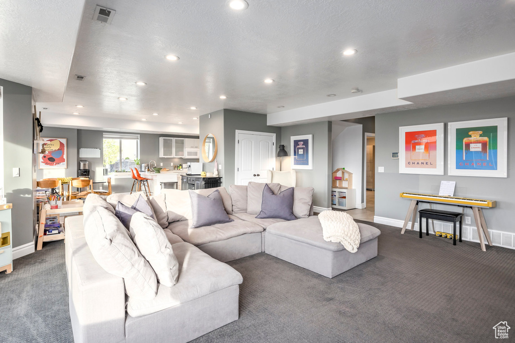 Living room with recessed lighting, baseboards, visible vents, and carpet