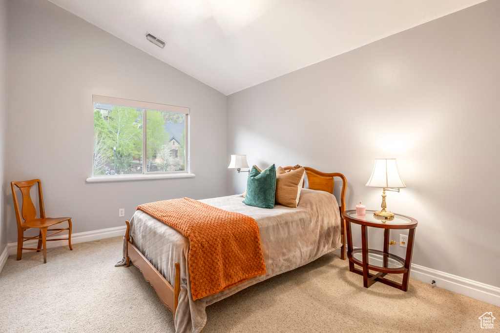 Bedroom with baseboards, vaulted ceiling, carpet flooring, and visible vents