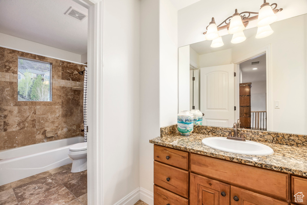 Bathroom with toilet, visible vents, shower / bath combo, and vanity