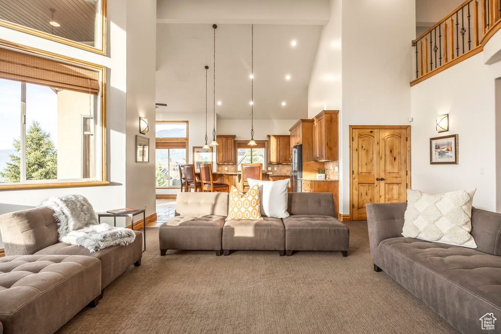 Carpeted living area featuring a towering ceiling
