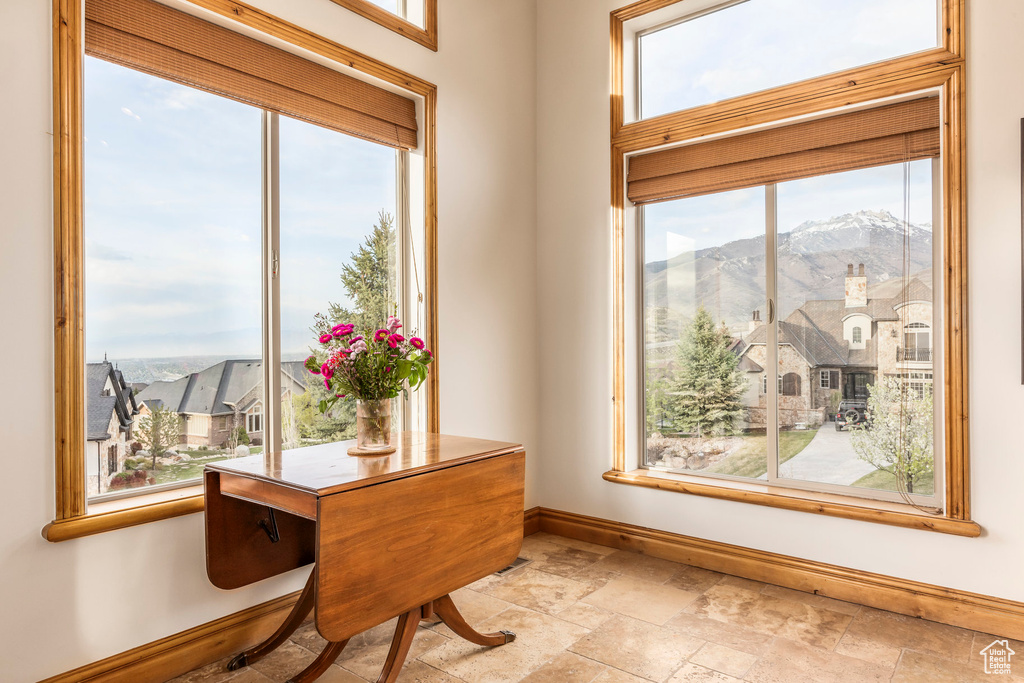Doorway with baseboards, a mountain view, stone tile flooring, and a residential view