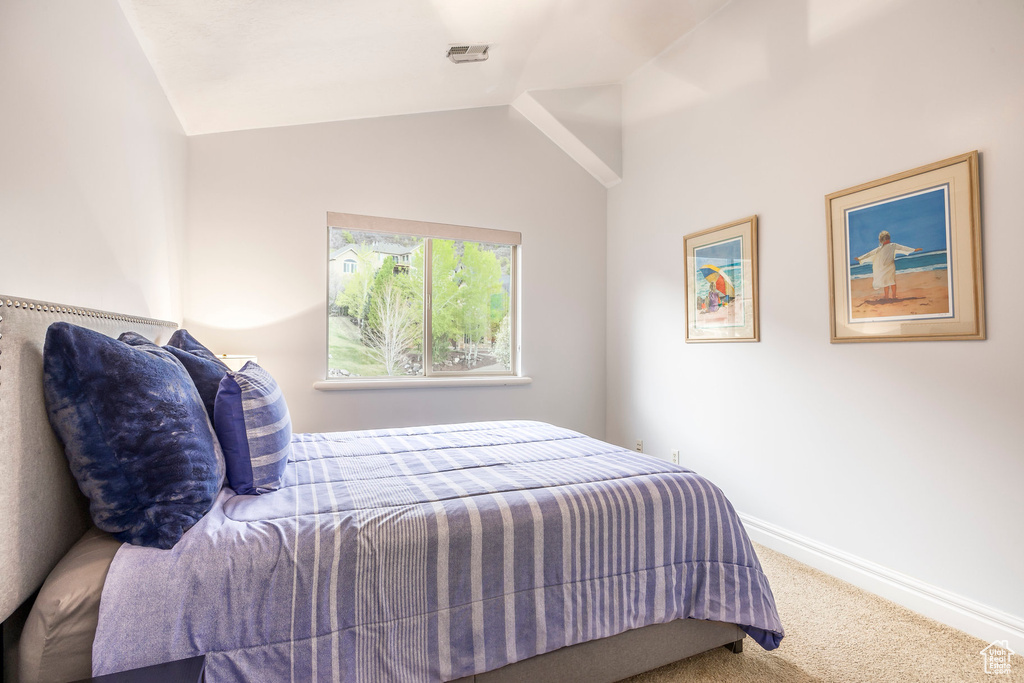 Bedroom featuring baseboards, carpet, and lofted ceiling