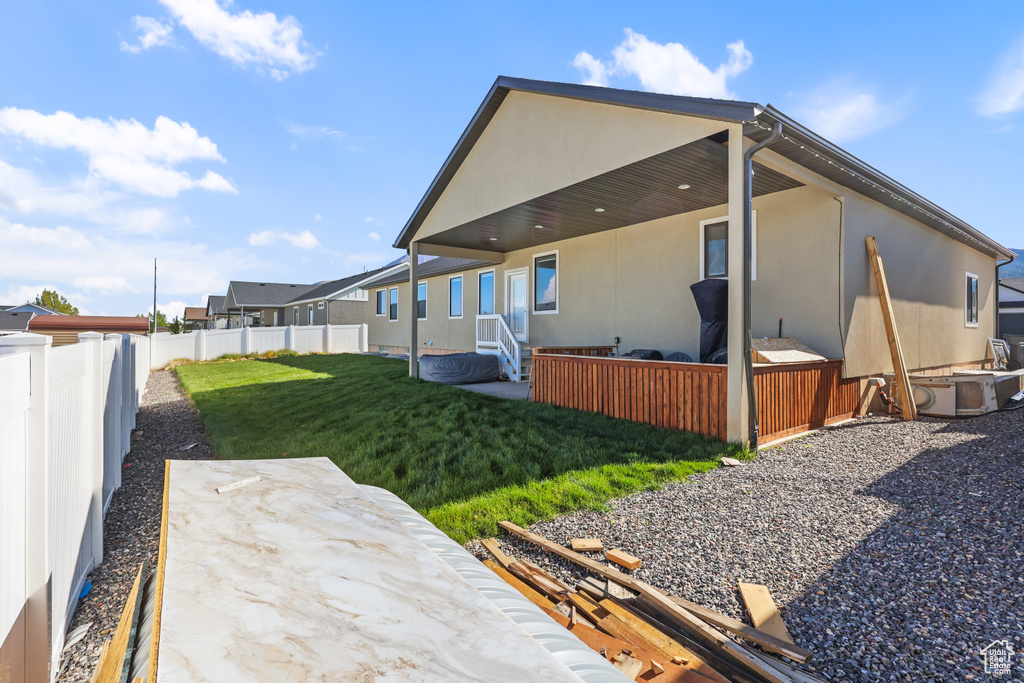 Rear view of property with a patio, a fenced backyard, stucco siding, and a yard