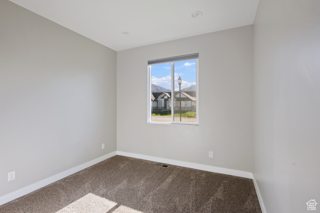 Unfurnished room with carpet floors, baseboards, and visible vents
