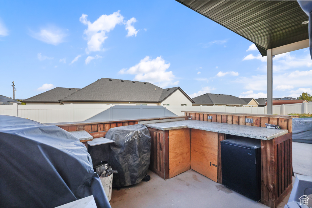 View of patio / terrace with area for grilling, a fenced backyard, and outdoor dry bar