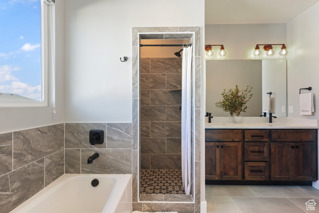 Full bathroom featuring double vanity, a shower stall, a sink, and a bath