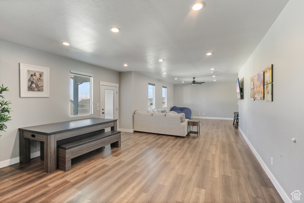Living room featuring baseboards, a ceiling fan, wood finished floors, and recessed lighting