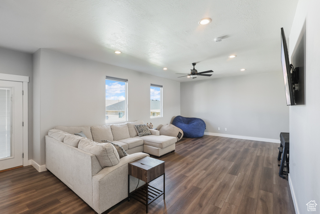 Living area with baseboards, a ceiling fan, recessed lighting, and dark wood-type flooring