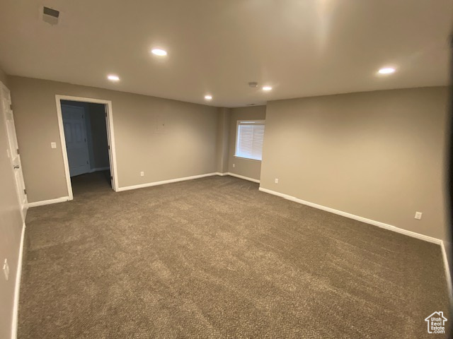 Spare room with baseboards, recessed lighting, and dark colored carpet