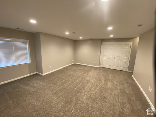 Unfurnished bedroom featuring recessed lighting, dark carpet, and baseboards