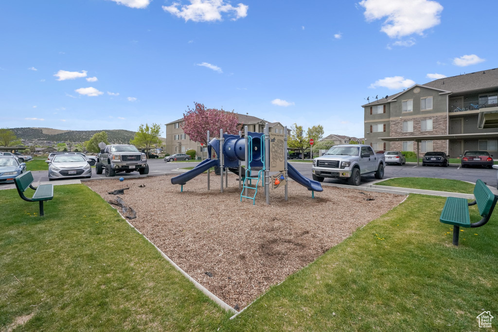 Community play area with a lawn and a residential view