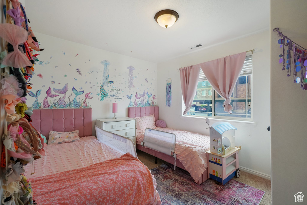 Bedroom with baseboards, visible vents, and carpet