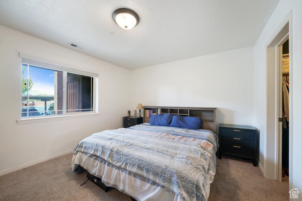 Bedroom featuring baseboards, carpet flooring, and visible vents