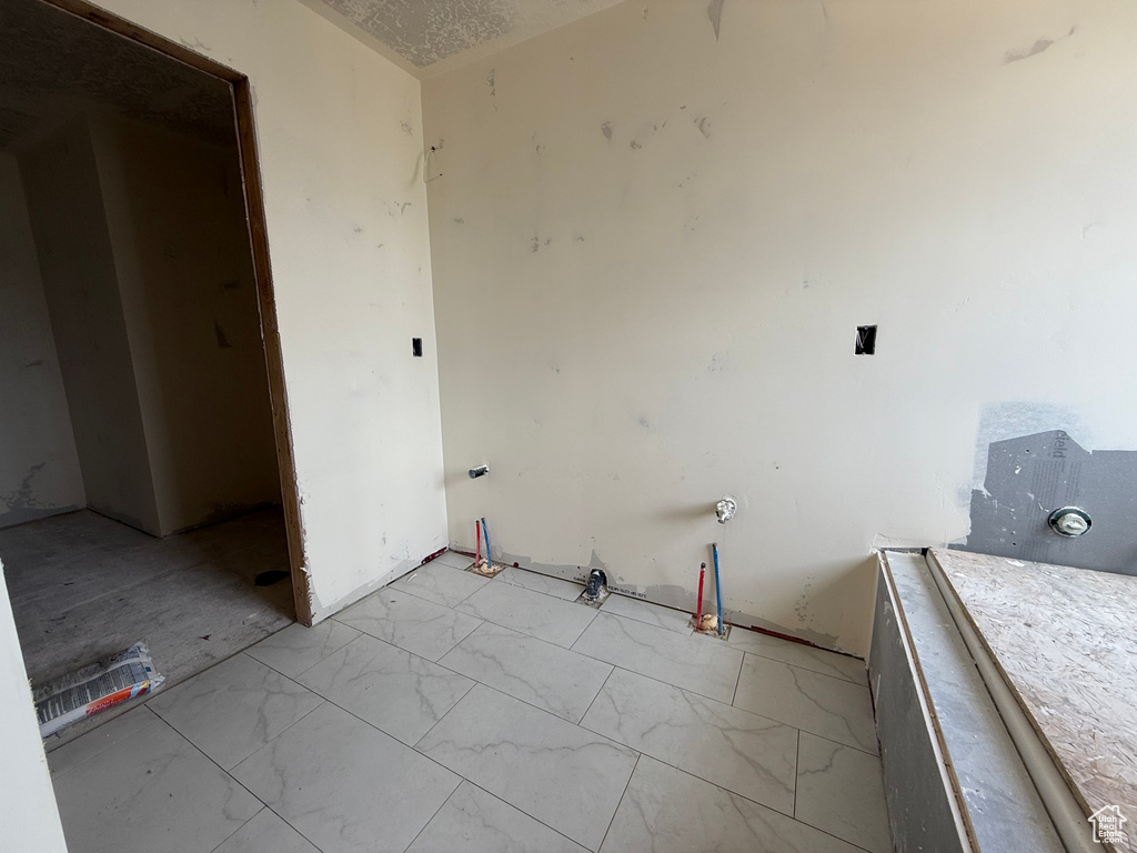Laundry area featuring light marble finish floors