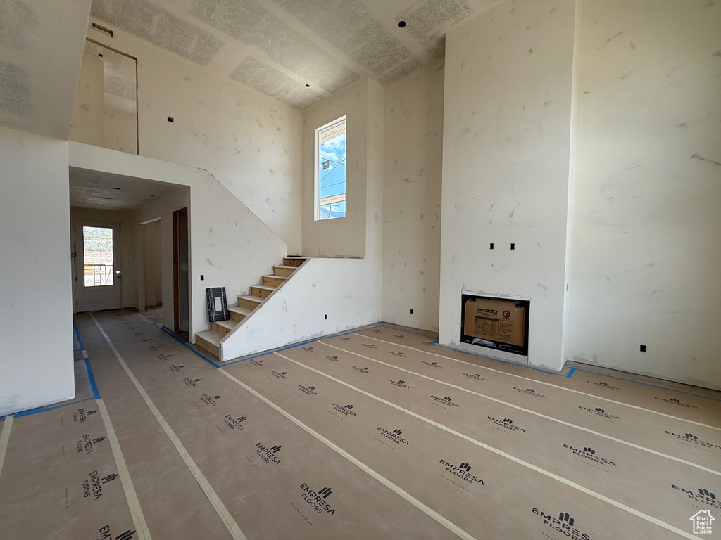 Unfurnished living room with stairway and a fireplace