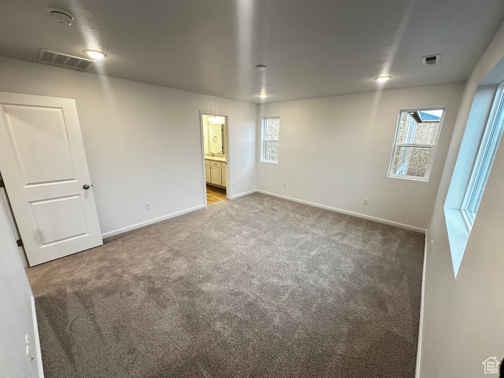 Carpeted empty room with baseboards and a smoke detector