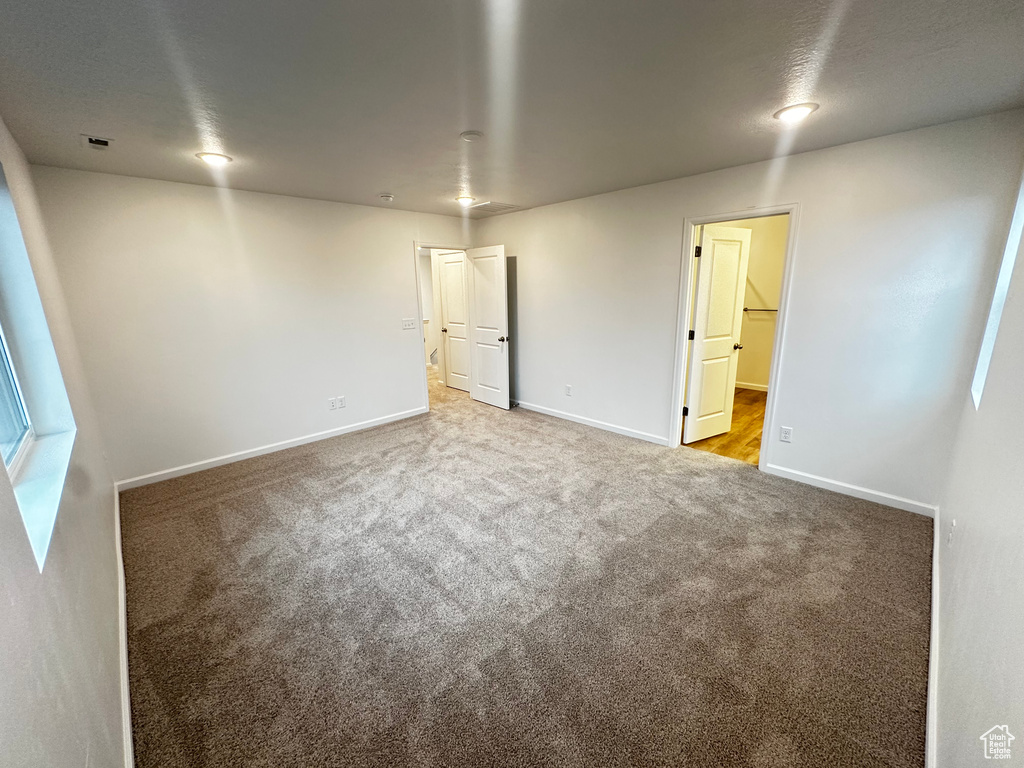 Spare room featuring carpet flooring and baseboards