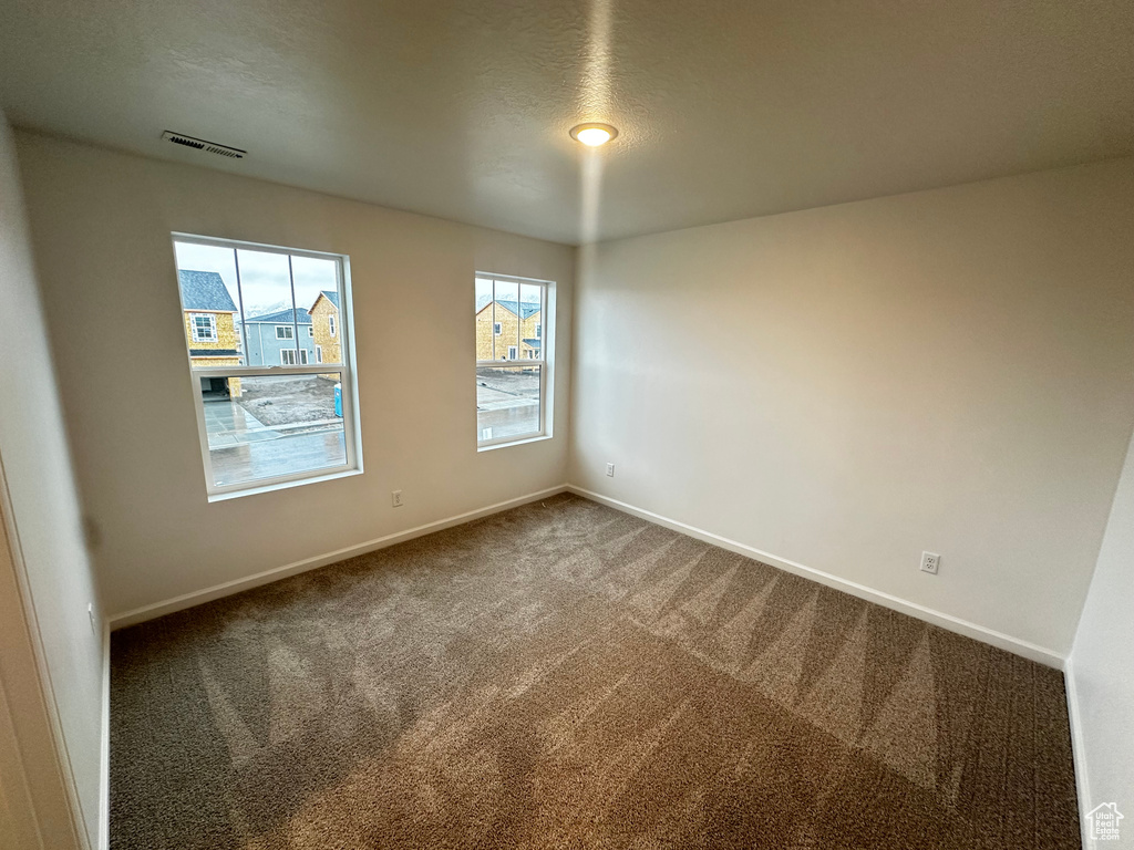 Carpeted empty room with baseboards