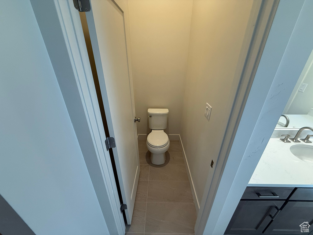Bathroom featuring toilet, tile patterned floors, and vanity