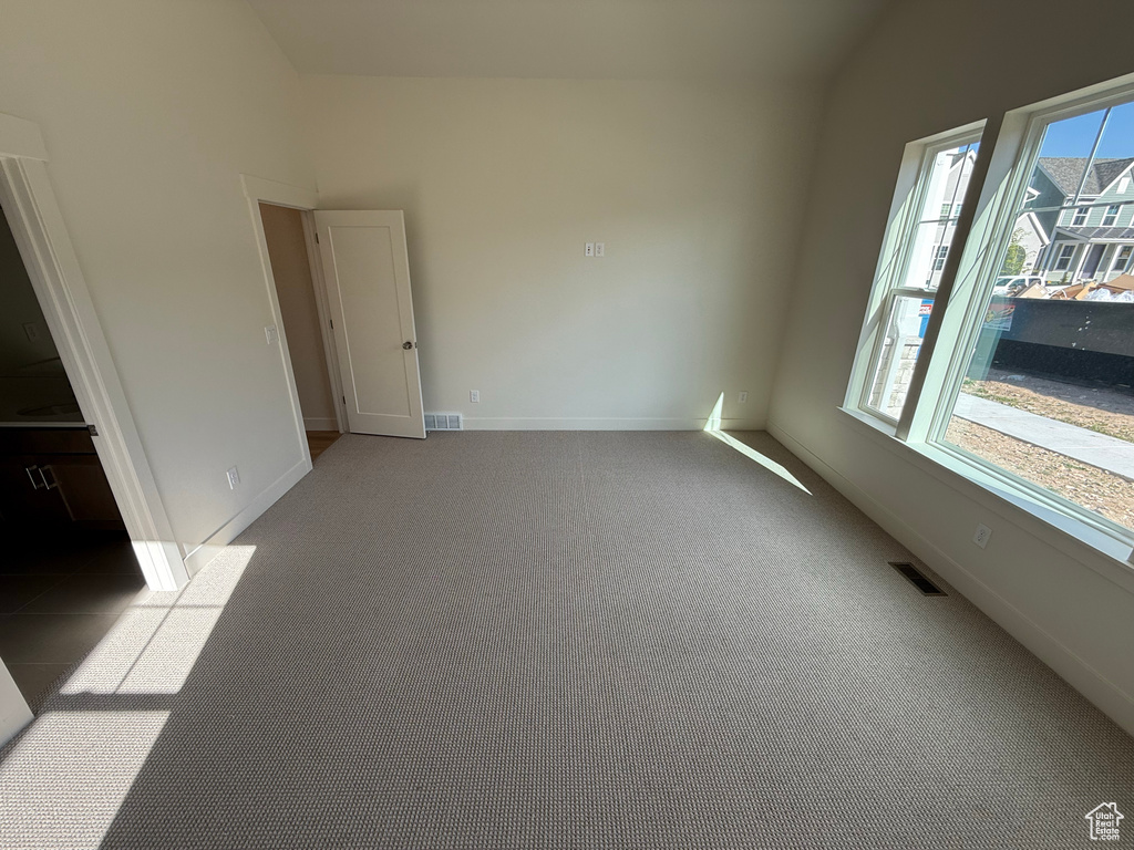 Spare room with visible vents, baseboards, and carpet floors