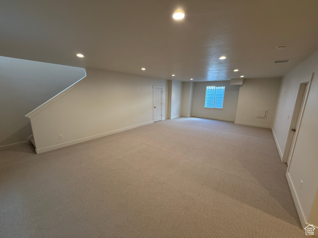 Below grade area featuring baseboards, recessed lighting, and light colored carpet