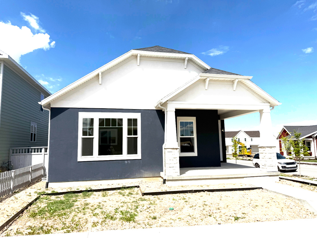 Bungalow featuring covered porch, fence, and stucco siding