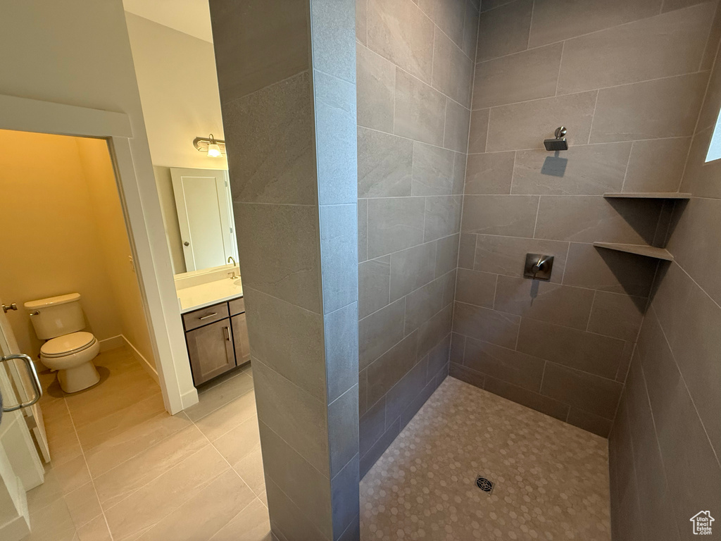 Bathroom with tile patterned flooring and tiled shower