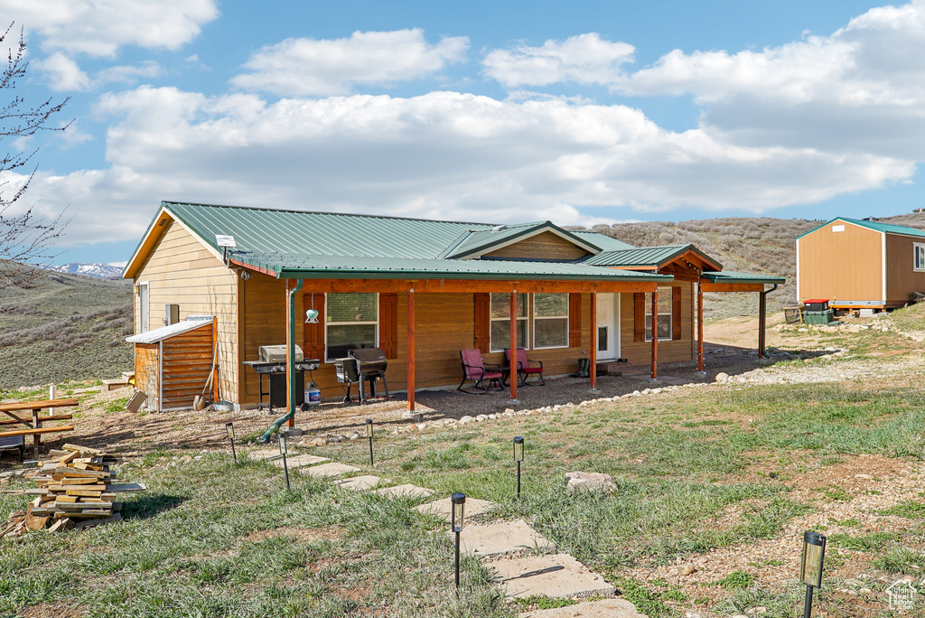 Back of property with a patio, metal roof, and a mountain view