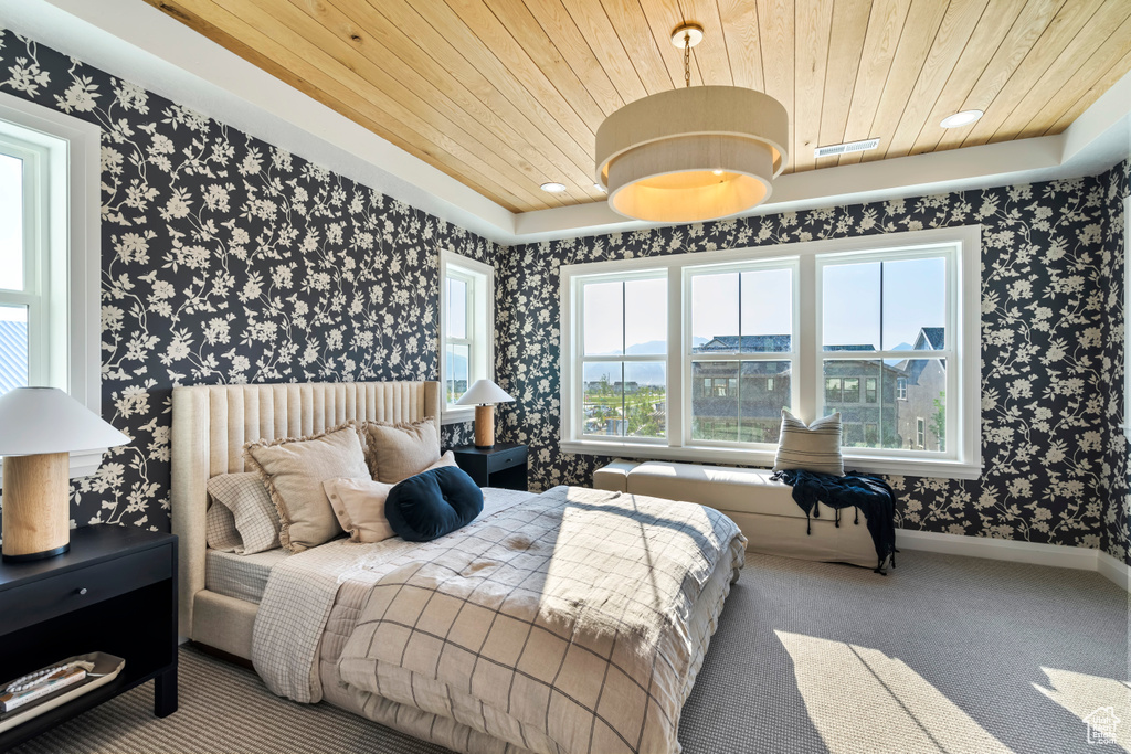 Carpeted bedroom with baseboards, wood ceiling, visible vents, and wallpapered walls