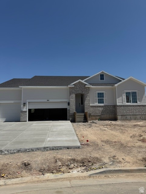 View of front of property featuring a garage and concrete driveway