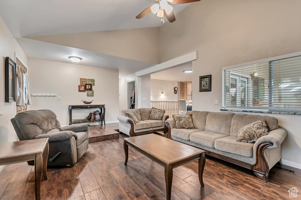 Living room featuring a ceiling fan, high vaulted ceiling, visible vents, and dark wood-style floors