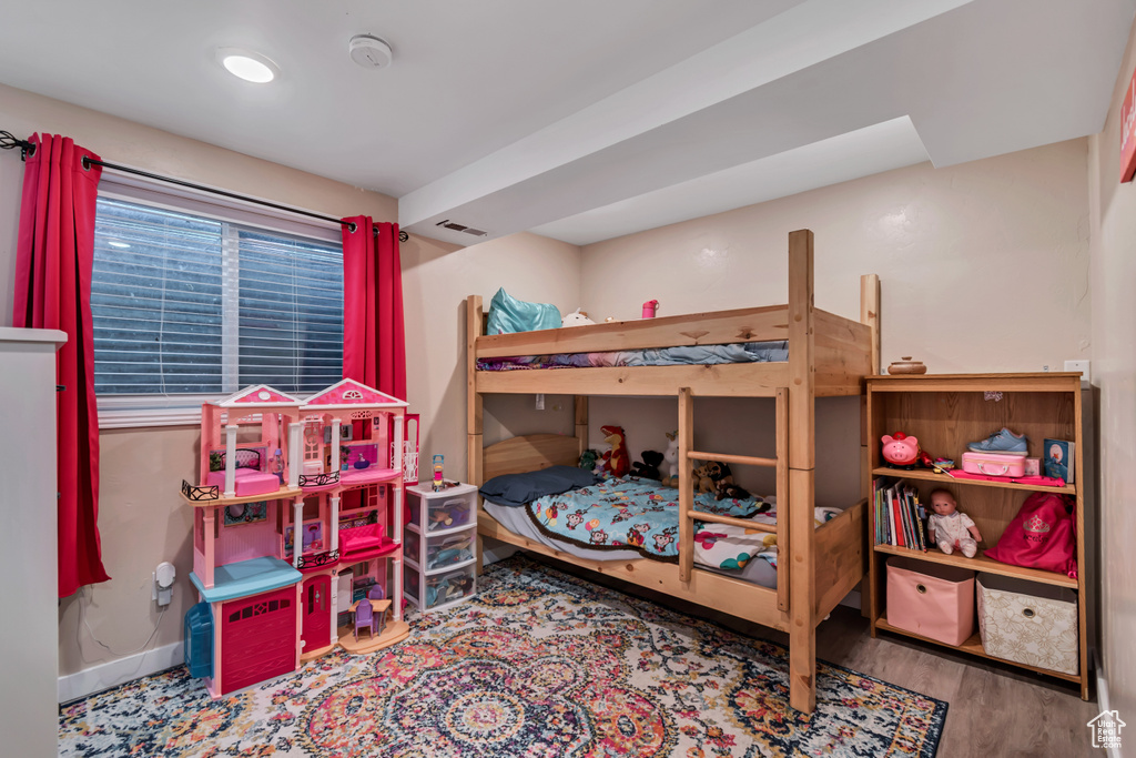 Bedroom with baseboards, visible vents, and wood finished floors