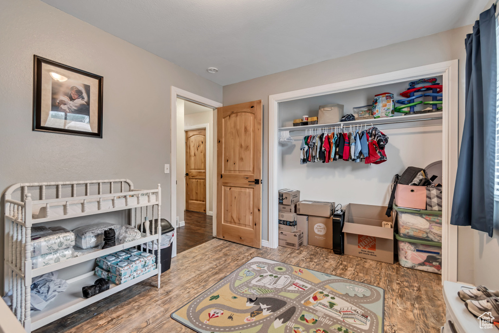 Bedroom with baseboards, wood finished floors, and a closet