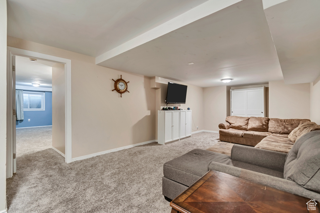 Living area featuring baseboards and light carpet