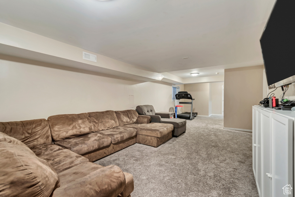 Carpeted living room featuring visible vents and baseboards