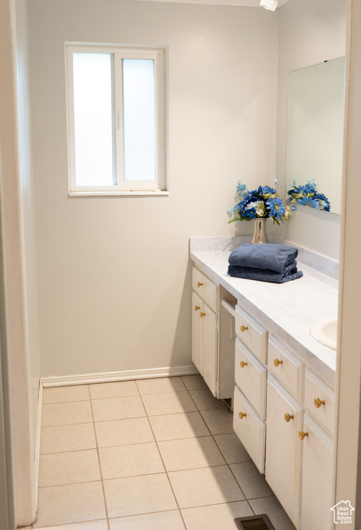 Bathroom featuring baseboards, tile patterned flooring, and vanity
