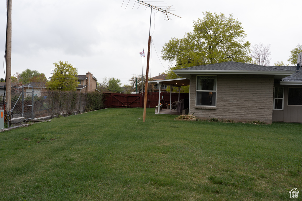 View of yard with a fenced backyard, a gate, and a patio
