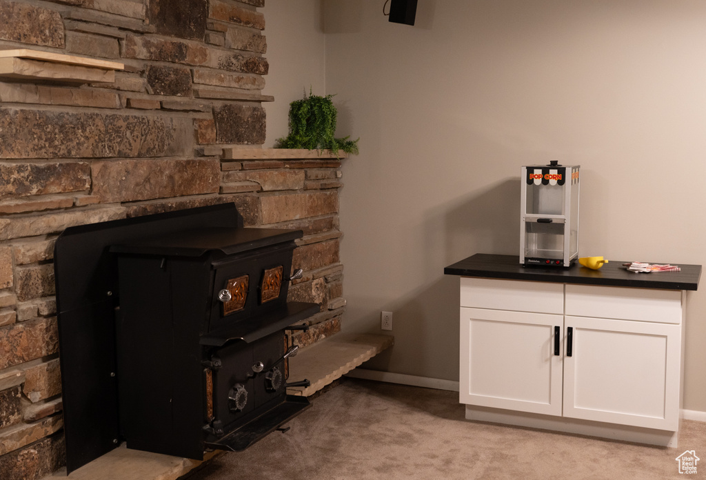 Room details featuring baseboards, a wood stove, and carpet