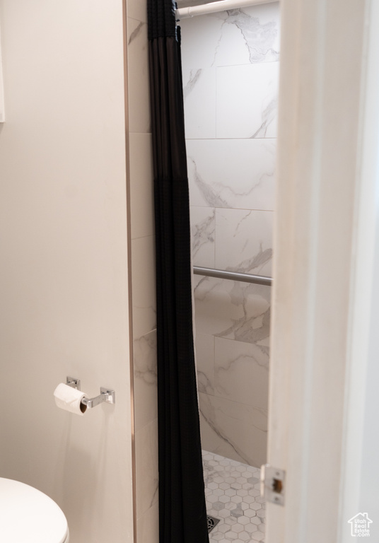 Bathroom featuring a marble finish shower and toilet