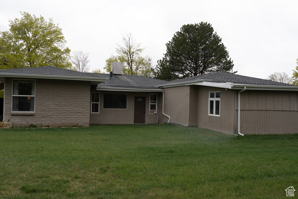Back of house featuring a lawn and a chimney