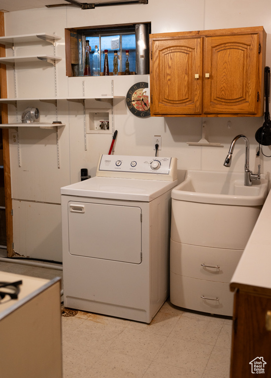 Laundry room featuring light floors, washer / dryer, and cabinet space