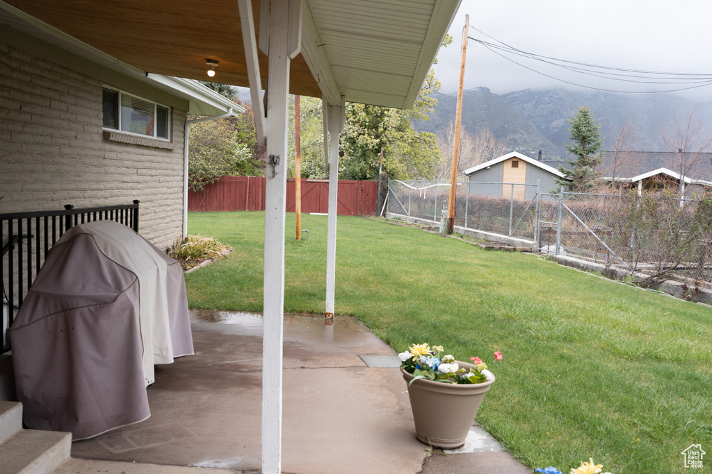 View of yard featuring a fenced backyard, a mountain view, and a patio area