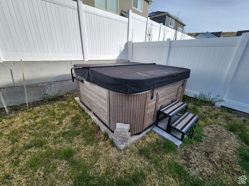 View of yard featuring a hot tub and fence